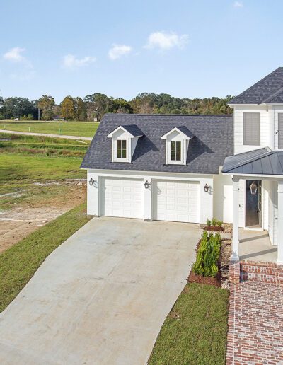 New two-story house with a driveway and partially landscaped front yard.