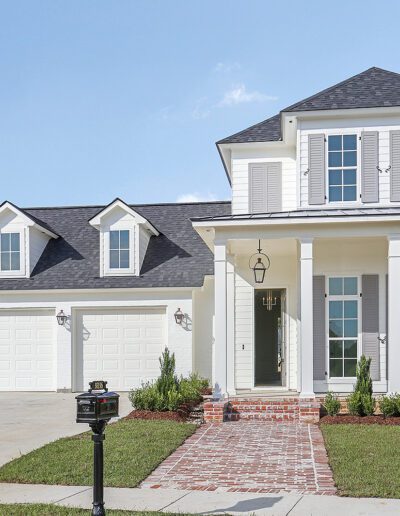 New two-story suburban home with a double garage and front porch under a clear sky.