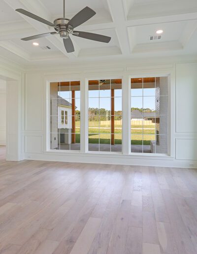 Bright and spacious unfurnished living room with a fireplace, large windows, and a view of the backyard.