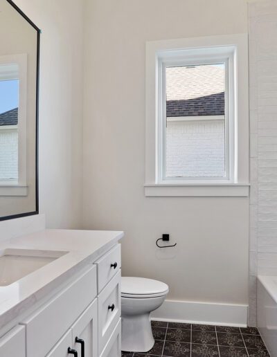 Modern bathroom interior with double vanity, black fixtures, and textured white walls.