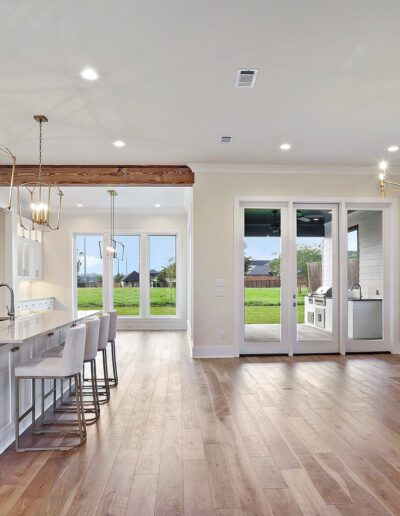 Modern kitchen with island and open-plan living area leading to an outdoor space.