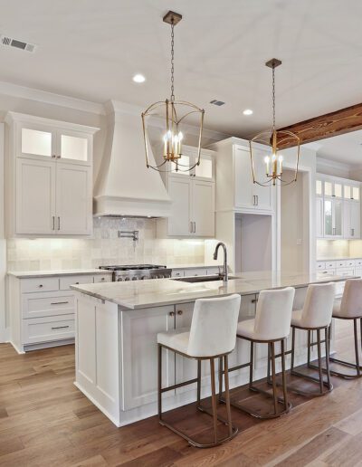 Spacious modern kitchen with a center island, white cabinetry, and hardwood floors.