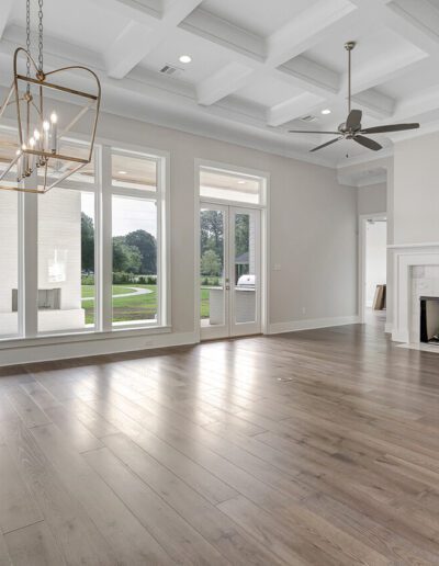 Spacious living room with a fireplace, large windows, and hardwood floors.