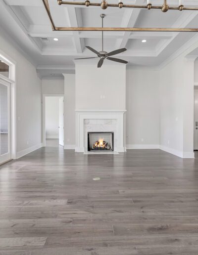 Spacious and modern living room with hardwood floors, a fireplace, and ample natural light.