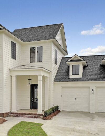 New two-story suburban house with a double garage under a cloudy sky.